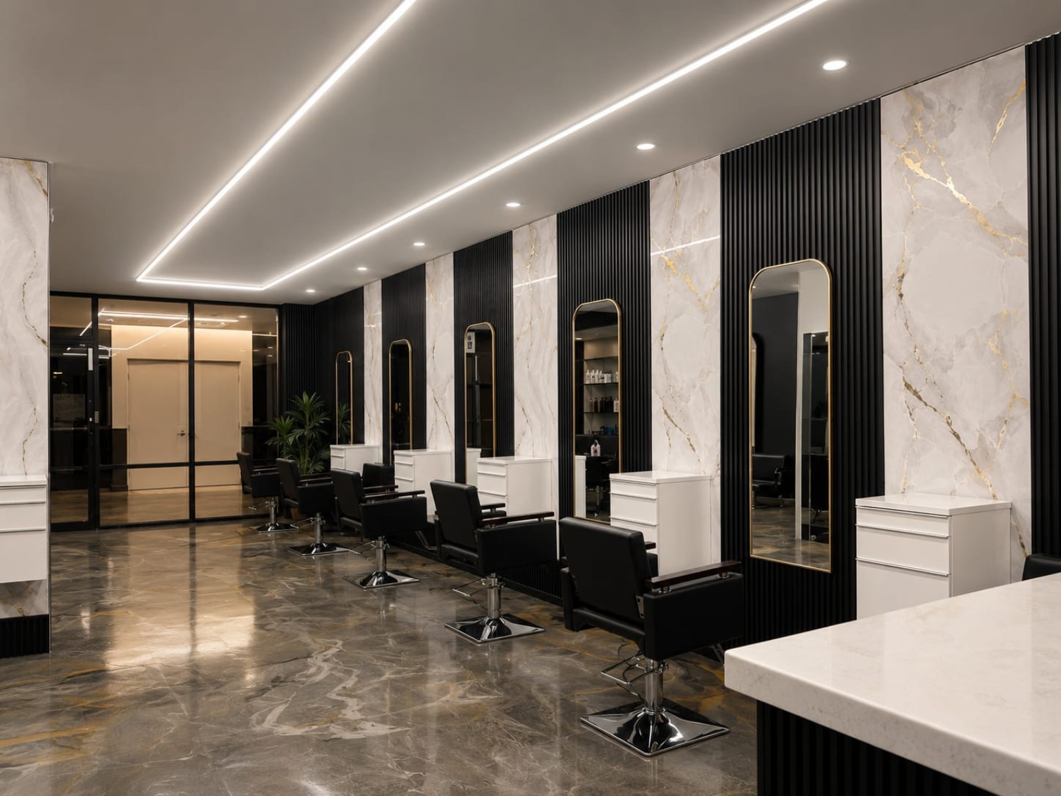 The salon styling stations with gold-framed mirrors and white marble panels